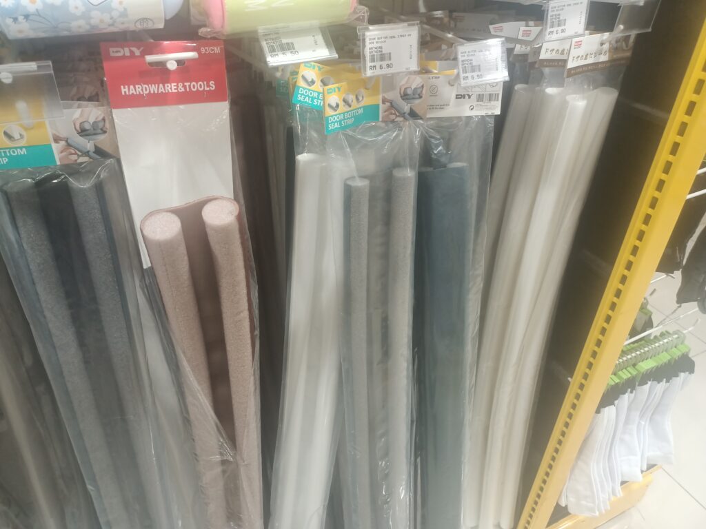 Fabric U-shaped door sweeps on sale in a homeware store.