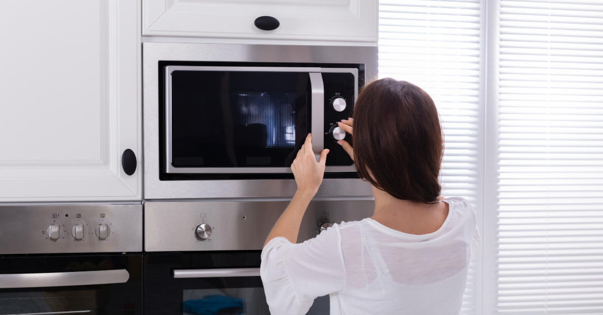 Woman using silent mode on a microwave