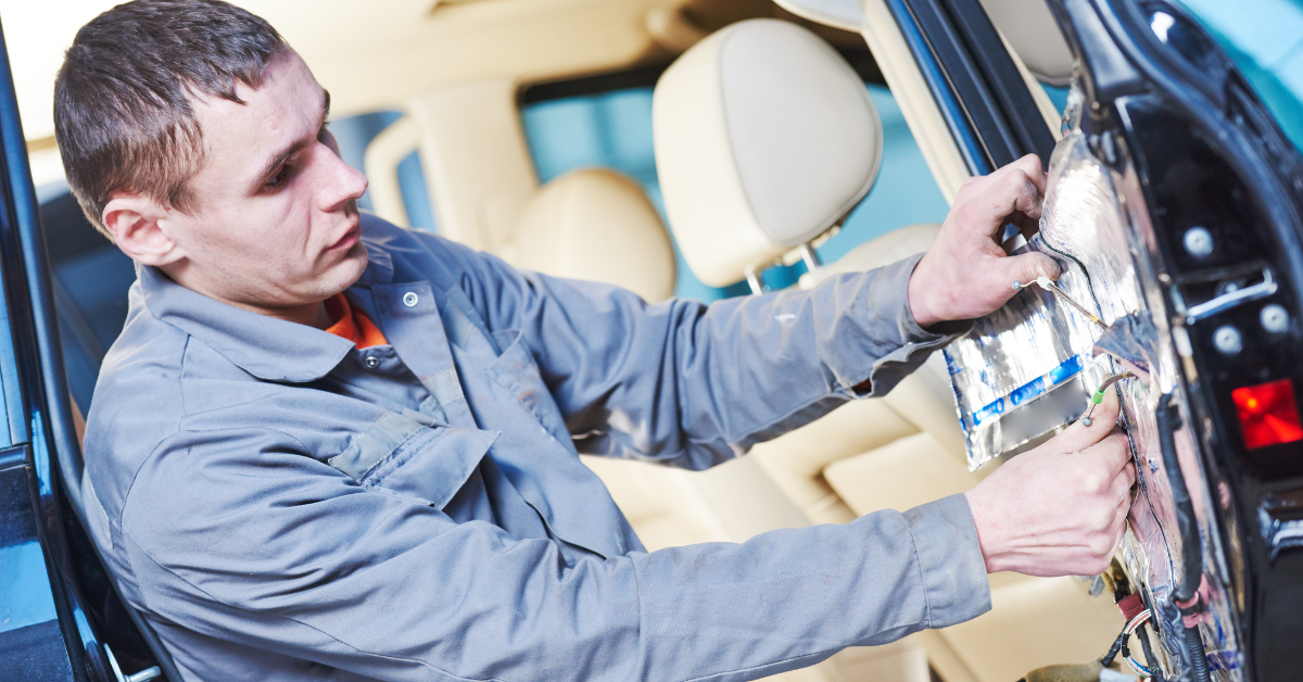 Mechanic installing insulation in car doors