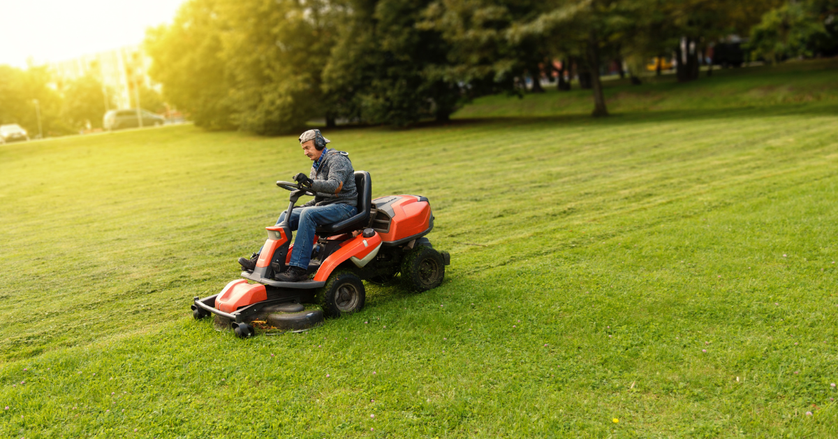 A man mows the grass wearing noise canceling headphones